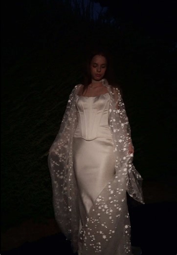 Bridal cape designed for getting ready and evening weddings. The Orion bridal cover up layers over your wedding dress or works as a getting ready outfit. One piece that moves with you through the whole wedding day. Would you wear this in the morning or the evening? #bridetok #weddingtok #weddingoutfit #bridalrobe #bridalinspo