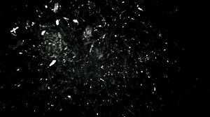 Super Slow Motion studio full-frame wide plate shot of window glass pane shattering and breaking on black background. Real smash explosion at high speed as action concept template and overlay element.