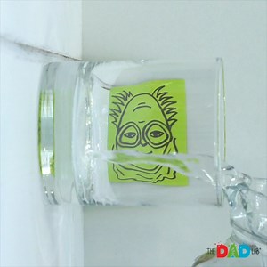 This simple experiment is usually done with a picture of a simple arrow that changes its direction after we pour water into the glass. However, we wanted to take the trick a bit further and introduce you to some mysterious faces that completely change after they are reversed. In the experiment, we see how the light bends when it passes through different materials. By the time the light from a piece of paper reaches our eyes, it goes through air, glass, water, glass and air again. That bends the 