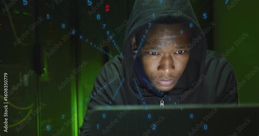 Man seated behind laptop turning head triggered by streaming numeric code overlay in data center