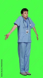 Side view Medical assistant shrugging and doing i dont know sign in studio, acting clueless and uncertain against greenscreen backdrop. Nurse in scrubs gesticulating doubtful reaction, unsure girl