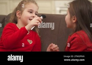 Two sweet little girls playing with a makeup brush. They tickling each other with brush and smiling Stock Video Footage - Alamy