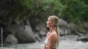 Attractive blond woman breathing in fresh air while sitting in Lotus pose, Yoga