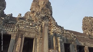 Bayon Temple with giant stone faces at sunset, Angkor Wat, Cambodia, tilt view, 4k