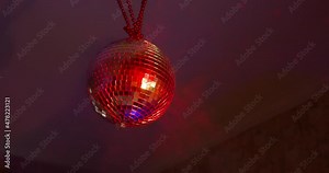 person rotates beautiful rotating sparkling mirror disco ball weighs on the ceiling in the room in the smoke. Concept of night retro party. Stock Video