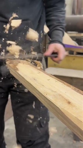 This is a wooden board that is being scraped neatly using a special sharp tool