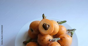 loquat or Eriobotrya japonica. Half and whole ripe loquat fruits on white background