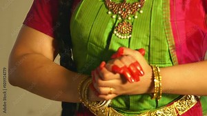 The painted fingers and adornment of bangles and bracelets accent the hand gestures of a traditional Indian dancer.