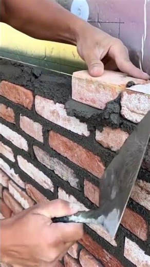 Brick wall construction aligned using string line and mortar #construction #popular