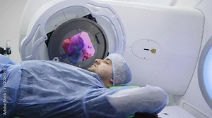 A young man undergoing radiation therapy for cancer in a state-of-the-art oncology clinic using a linear accelerator. The concept of modern approaches to oncology treatment.