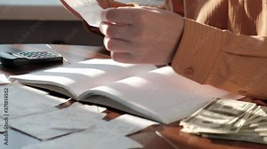 Man counting money summing up expenses on checks, close-up