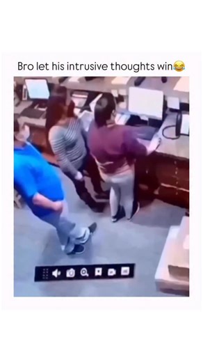 MOVIE FUN 🍿 on Instagram: "This video appears to be a short, humorous clip captured by a security or surveillance camera, showing three people interacting behind a counter in what looks like an office or reception area.The video features three individuals: a man in a blue shirt and face mask, a woman in a striped top, and another woman in a purple top. They are all standing near a wooden counter with computer monitors.The action starts with the three people standing close together. The woman in