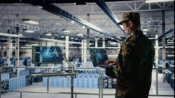 Soldier in engineering role uses AI application on laptop to manage server hub systems. Army commander reviews secret intelligence information using artificial intelligence in data center, camera A