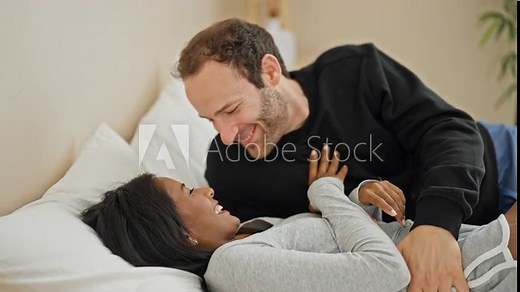 Beautiful couple lying on bed kissing at bedroom Stock Video