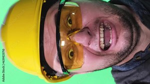 A madly angry construction worker bangs a hammer on his hard hat. Vertical video