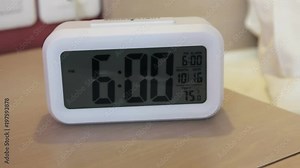 electronic alarm clock stands on a bedside table in the room or hotel room. dolly video