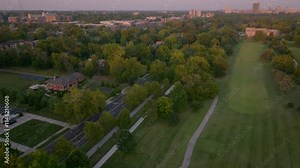 Stunning aerial view of Forest Park golf course on a summer evening, showcasing lush green fairways, Lindell Blvd, and the St. Louis skyline. Perfect for travel, nature, and outdoor recreation themes.