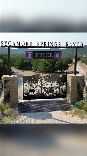 Custom ranch entrance with stone columns, automatic slide gate, custom overhead and custom art.