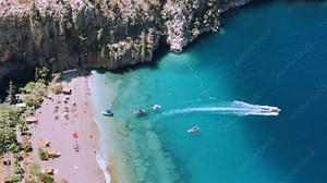 The pristine coastline and crystal clear waters of the Butterfly Valley in Oludeniz, Fethiye, Mugle, Turkey. The beach of the Valley of the Butterfly. A beach with fine white and soft sand. 4K