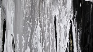 Black and white swirly fluid lines dropping from top to bottom in abstract patterns.