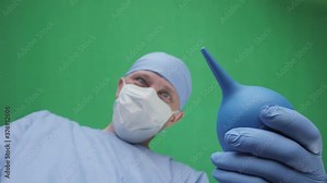 Doctor with an enema. A doctor with an enema in his hands stands above the patient. First-person view, green screen background. Doctors face with an enema in front of a patient