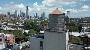flying counter clockwise around roof top water tank with downtown Brooklyn skyline in bkrd