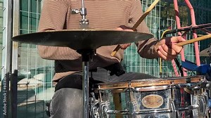 Street drummer. Video of the drummer solo. A musician hands skillfully play a colorful, weathered drum on the street, evoking a sense of urban artistry. Concept: Street performance showcasing raw