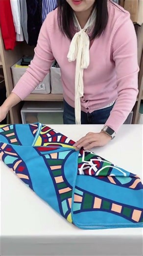 A professional organizer teaches you how to use the roll up method to tuck a bath towe