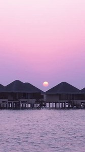 Sunset scene at Maldives beach, luxury water lodges. Travel destinations. Vertical footage