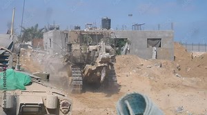 IDF Caterpillar D9 armored bulldozers moving slowly on destroyed city streets during Israel Hamas war