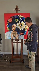 The Muse is a vibrant portrayal filled with symbolism and confidence. The deep red background radiates passion, setting the stage for the central figure. Her lush afro, resembling a living garden, features a striking rose, symbolizing love and power. As the eye moves across the canvas, sunflowers blend into the hair, representing warmth and vitality. This textured masterpiece, painted in midnight black with deep blue and violet strokes, embodies both cosmic and earthly qualities. The woman’s reg