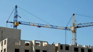 Work of two construction crane during build of house in new neighborhood. Tower cranes are building a house. Accelerated video..