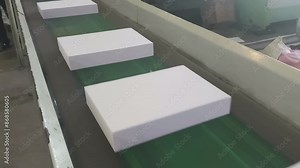 Cut pack A4 sized copier papers are passing though conveyor belt before cover is made. Automated copier manufacturing process in a paper manufacturing plant, India.