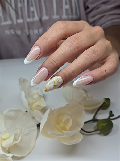 Sophisticated almond nails with translucent nude base and subtle flashes, enhanced with impeccable white French that brings freshness and elegance 🤍 The special touch is given by the marbled accent in cream and gold, an artistic fusion that conveys luxury, balance and timeless style. A set designed for hands that want to look fine, polished and personality, without losing the classic essence. 💎 Exclusive design 💎 Handmade details 💎 Professional and brilliant finish #AlmondNails #FrenchElegan