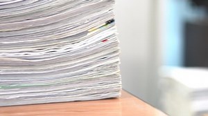 stack of documents on desktop in office.
