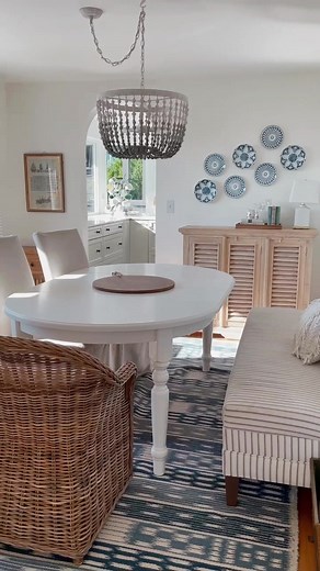 Our dining room in our last house - arched doorway, blue and white plates on the wall, wicker chairs, slipcovered linen slipper chairs and dining banquette 💛 The new dining space in our new house is under construction as we speak, it will have a built-in banquette bench with library bookshelves 😍 Can’t wait to see it come to life! #coastalliving #archeddoor #cottagestyle #coastalgrandmotherstyle