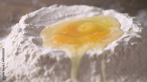 Large egg splashing into pool of three eggs and flour shot in slow motion 120 fps