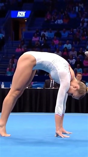 USA Gymnast in White Bends Back into a Powerful Bridge on Competition Floor