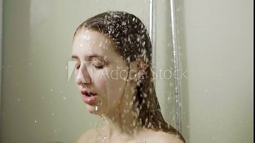 Young beautiful woman taking a shower in a bathroom. Slow motion. HD