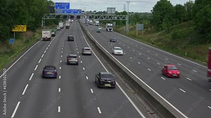 Timelapse of traffic on the M1 smart Motorway dual carriageway road with overhead traffic signals and no hard shoulder in Northamptonshire in England.