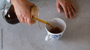 Barista preparing filter coffee, pouring coffee and hot water into paper filter. Alternative coffee brewing methods. Concept for third wave cafes