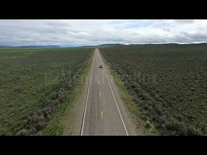 Stock Video - Drone following car on road in a vast landscape
