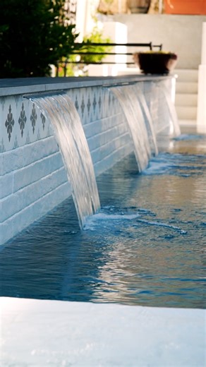 Premier Pools & Spas San Diego | Custom Pools on Instagram: "This perimeter overflow pool + spa in Poway is pure backyard luxury—featuring three custom water features, porcelain coping and tile, a contoured Baja shelf with umbrella and a Pebble Sheen interior that ties it all together. Designed to impress, built to enjoy. #PowayCA #LuxuryPools #PerimeterOverflow #CustomPools #SoCalLiving"