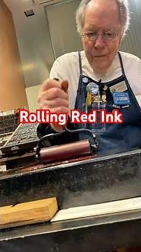 Rolling out rhodamine red rubber base ink on the ink stone for letterpress printing