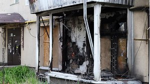 Burnt down apartment. The consequences of a fire due to a short circuit in the wiring in a multi-storey residential building. Fire in the house. Windows and balconies of an apartment building.