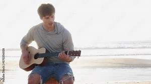 Man playing guitar on beach