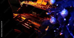 Woman playing piano at night. Focusing camera on beautiful Christmas tree