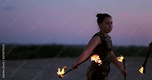 Professional dancers women make a fire show and pyrotechnic performance at the festival with burning sparkling torches.