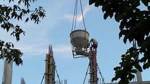High-Rise Construction: Concrete Pouring into Formwork Using Tower Crane and Hopper | Urban Residential Development with Nature Preservation | Modern Building Techniques in Growing Cityscape