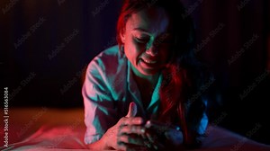 an adult pretty woman has fun at night talking on the phone video with a loved one. neon lighting and insomnia